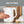 White electric kettle with side handle and gold base trim; hand holding