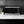 Black microwave oven on countertop with keypad and cooking utensils