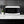 Black microwave oven on countertop with keypad and kitchen tools